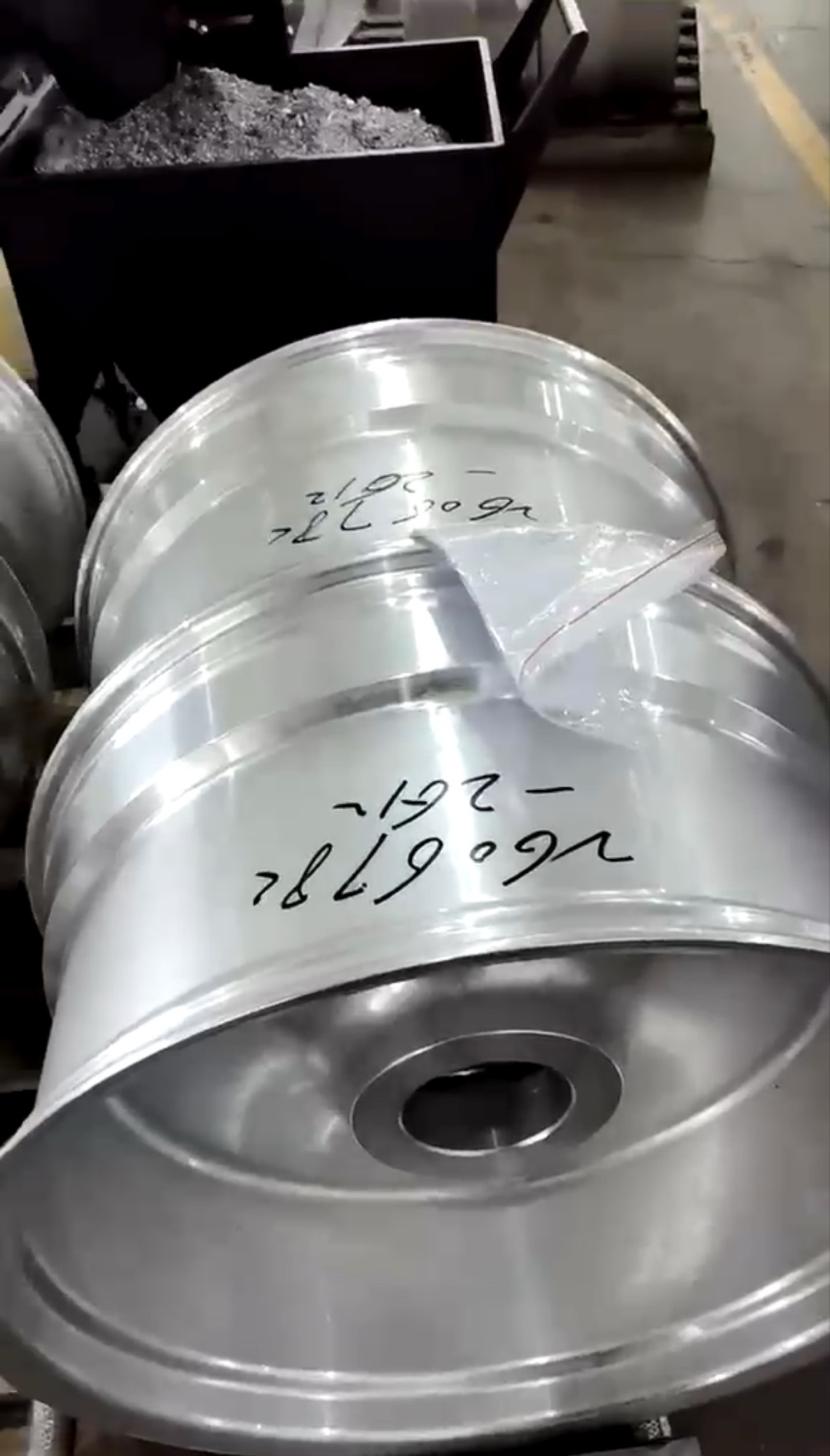 Freshly forged 26x14 aluminum wheel blanks off the press, still marked with size in Sharpie